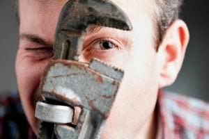 person looking through rusted wrench