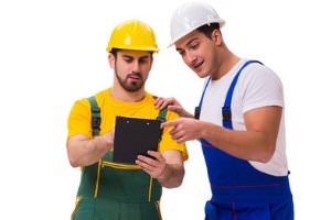 two plumbers looking at form