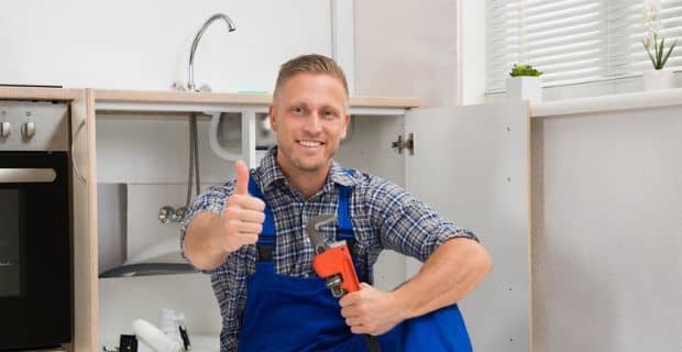 plumber giving a thumbs up while holding a wrench