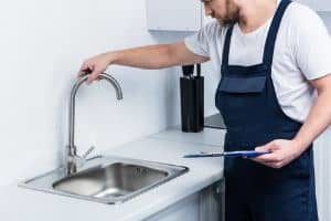 plumber checking sink faucet